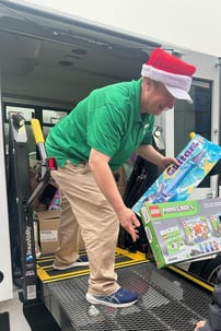 Astoria team member putting donated gifts on a bus