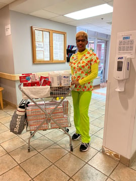 Marian, a PSW and IPAC Champ stands with her suply cart