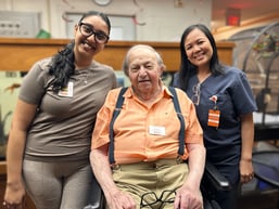 Monty sits in between two Sienna team members and is smiling