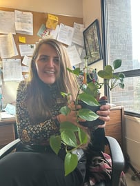 Sarah Christmas, Sienna Social Worker, holding a plant in an office setting