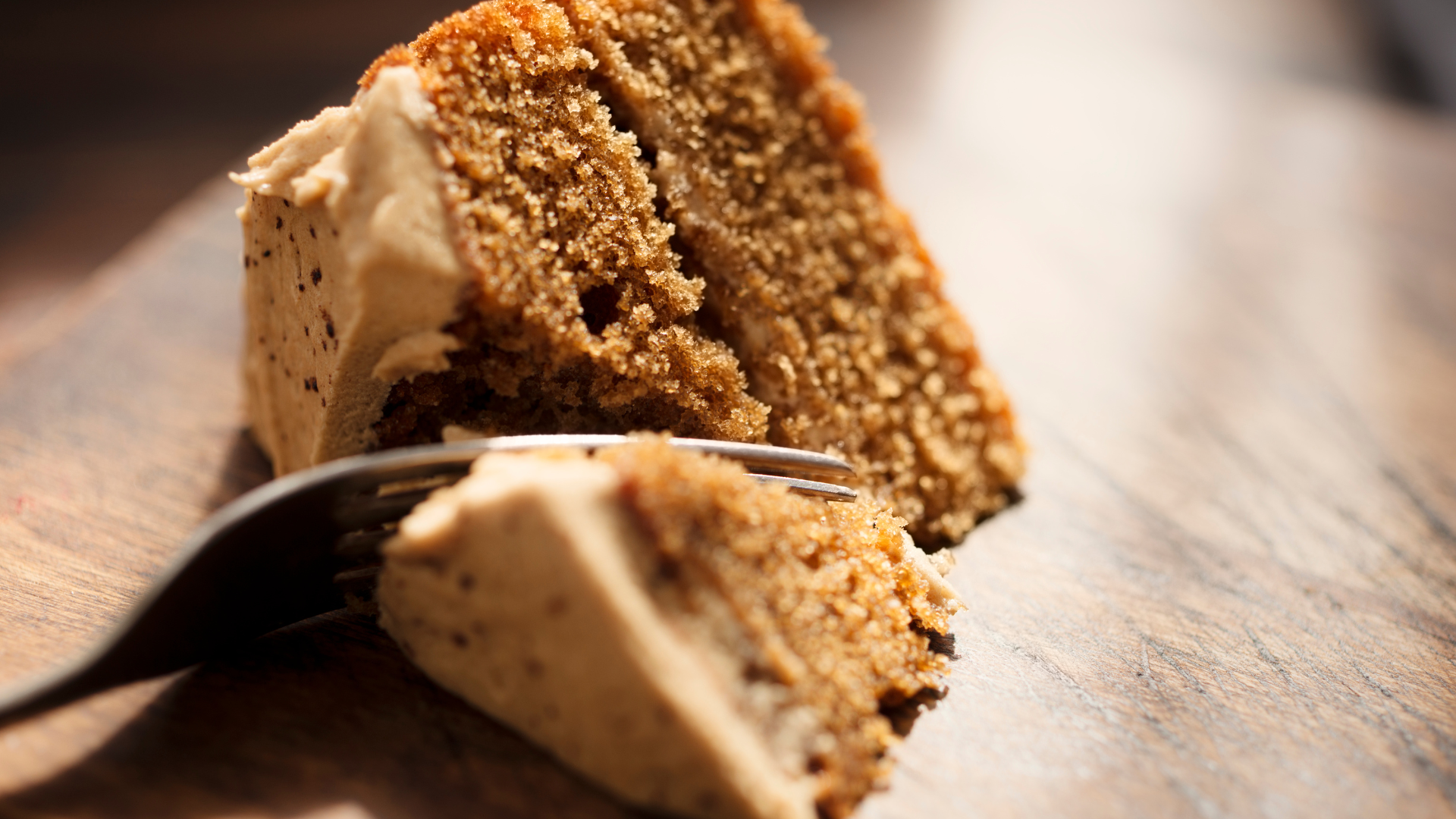 Fork cutting into slice of cake