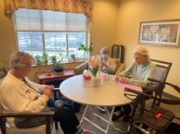 Ellen, a volunteer at Case Manor Community, knits with residents