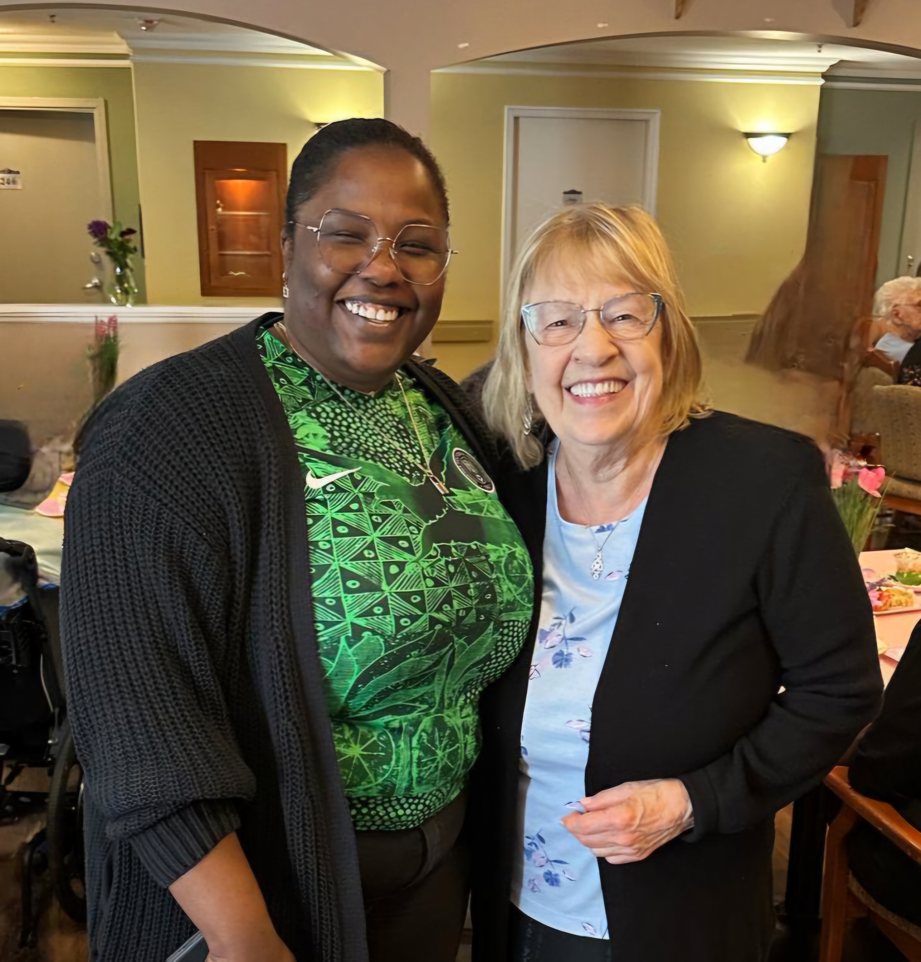 Adebusola Oluteye, nurse standing with resident and smiling 