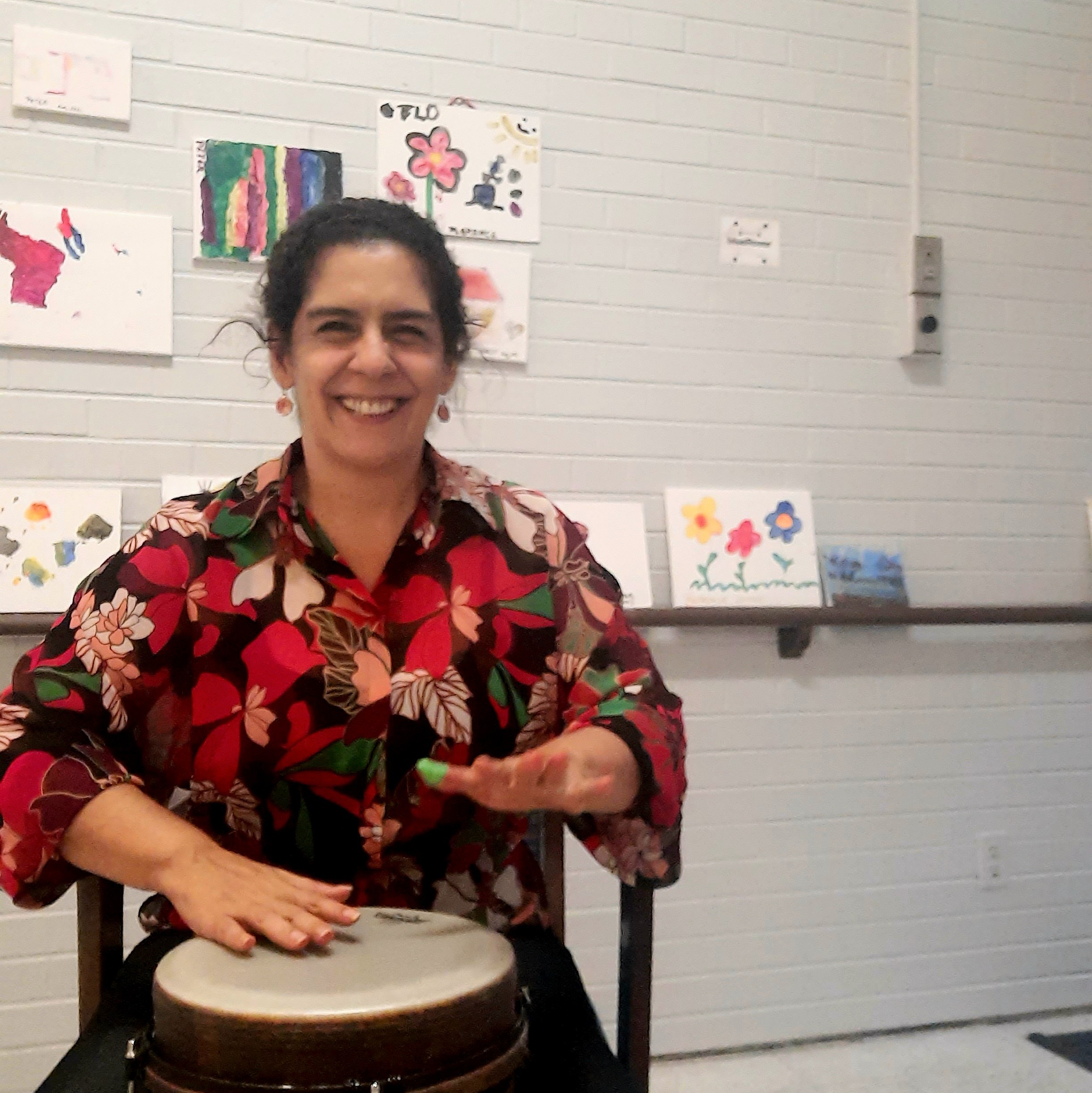 Fernanda smiling and playing the drums
