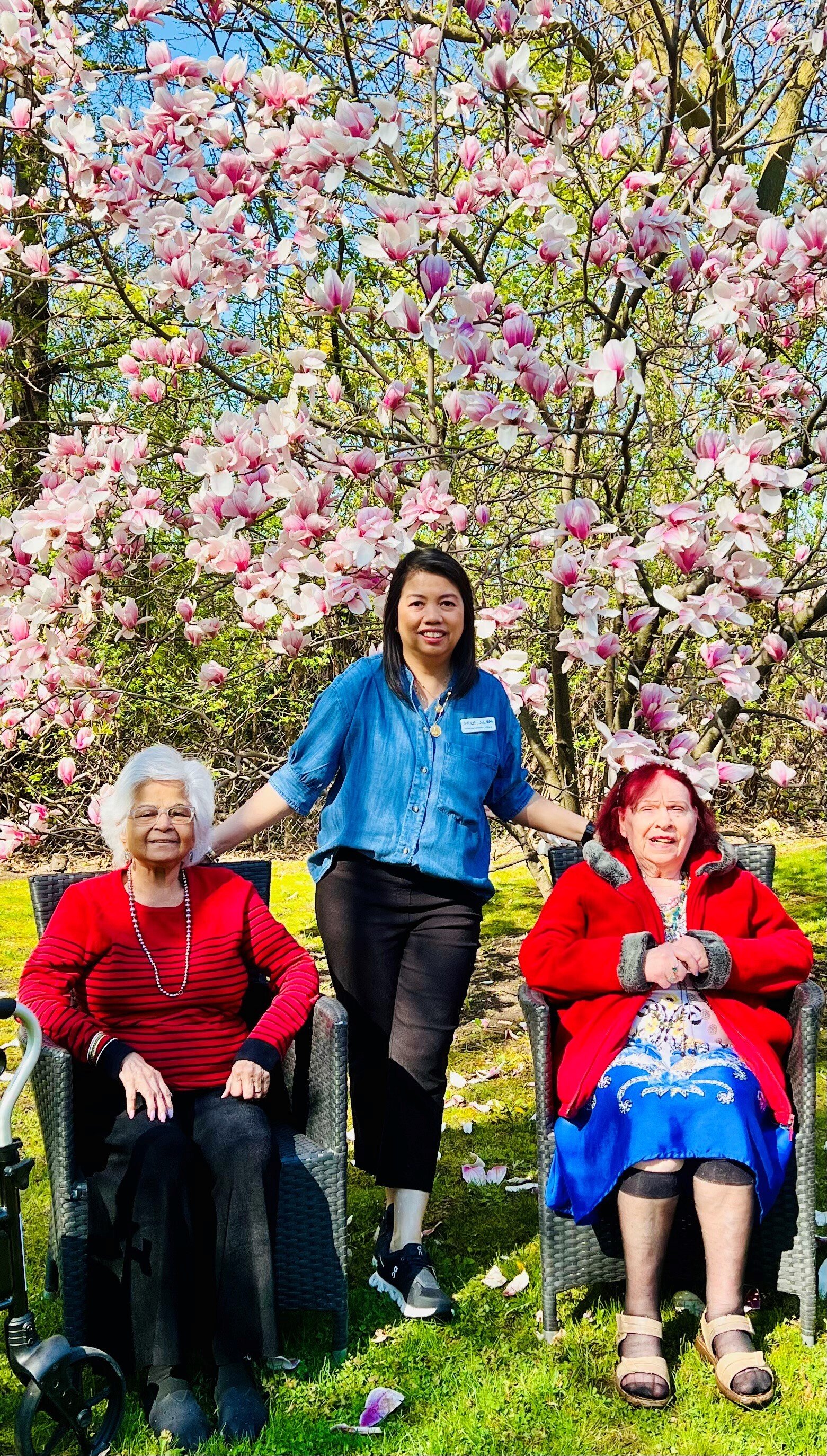 Liezl Lafrades, Associate Director of Care at Sienna's Streetsville Community stands in between two residents