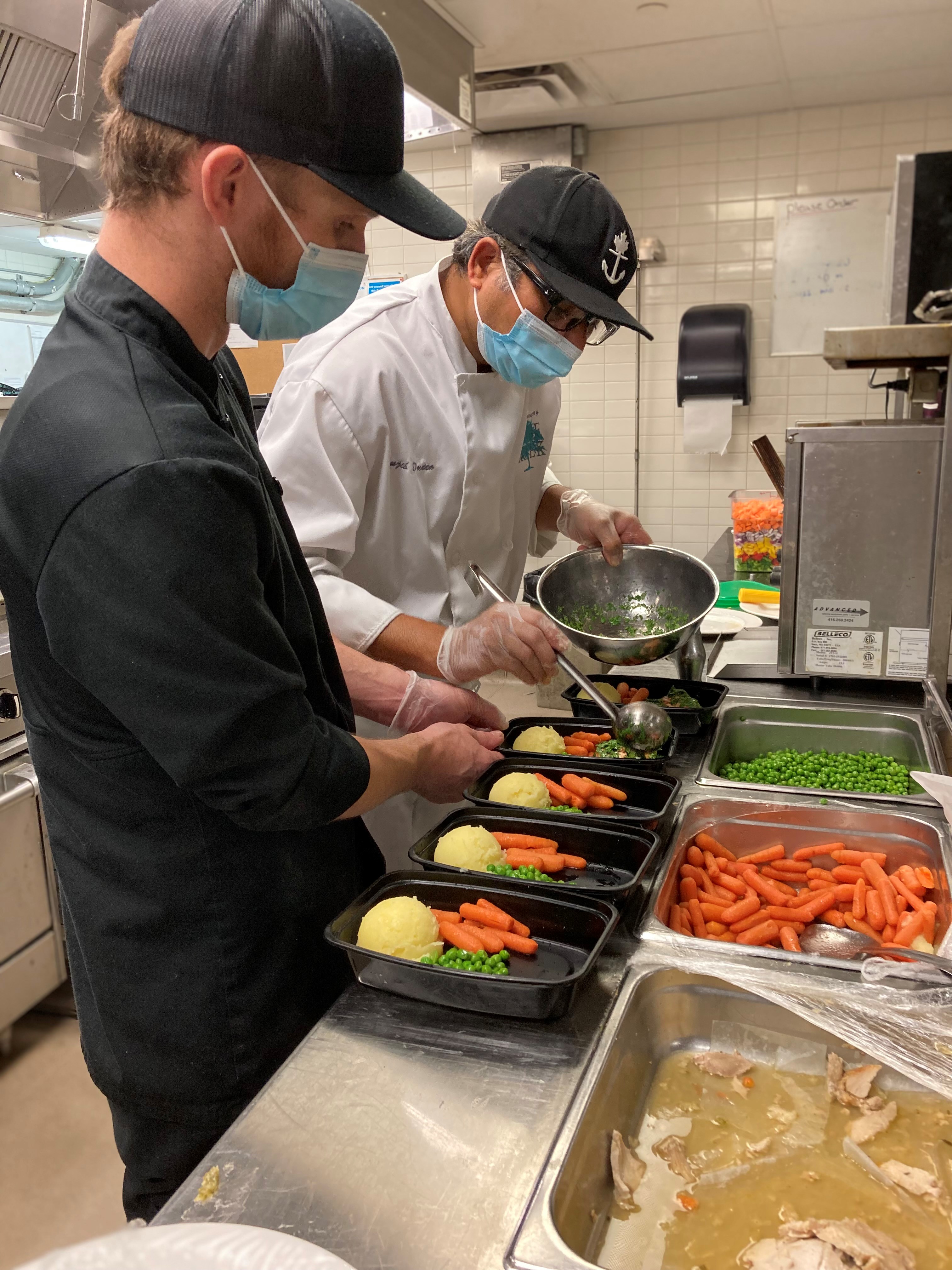 Two Lynde Creek Gardens team members preparing Thanksgiving meals 